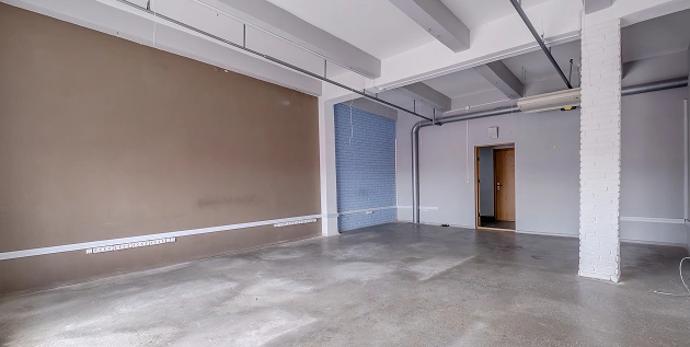 Grote, lichte ruimte in renovatie met bruine tinten en een wit plafond.