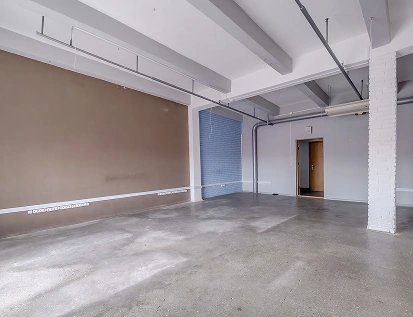 Grote, lichte ruimte in renovatie met bruine tinten en een wit plafond.